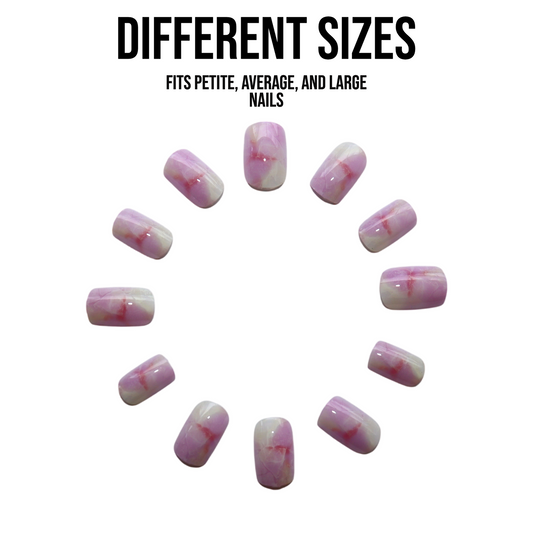 Short square glossy press-on nails in a baby pink and white marble design arranged in a circle outside the packaging to show shape, finish, and color